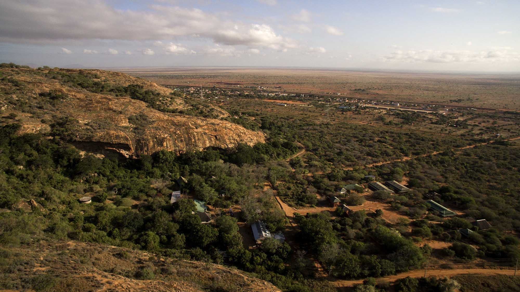 Aerial of a remote tented camp in escarpment landscape